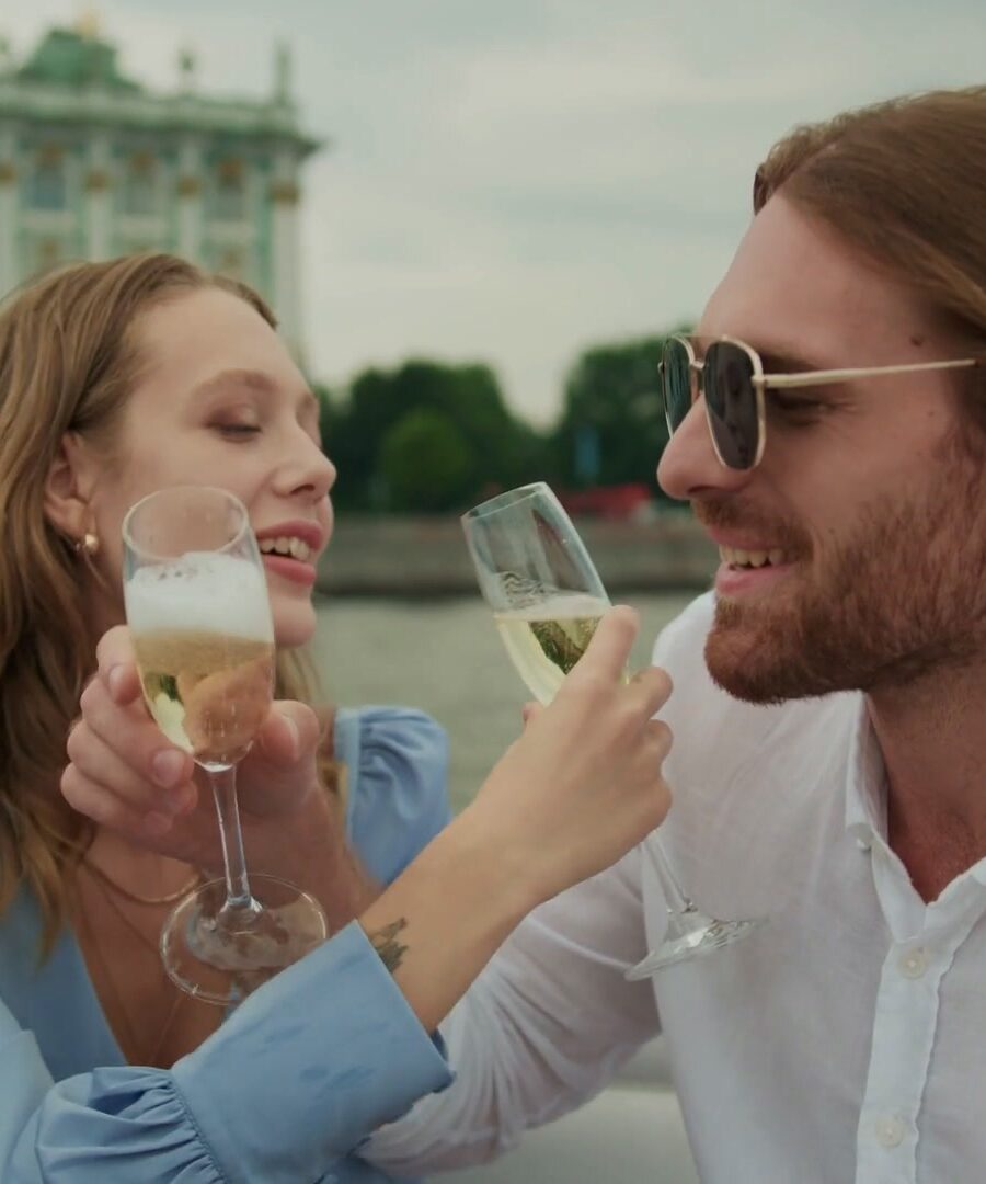 Two travellers raising glasses above the sea