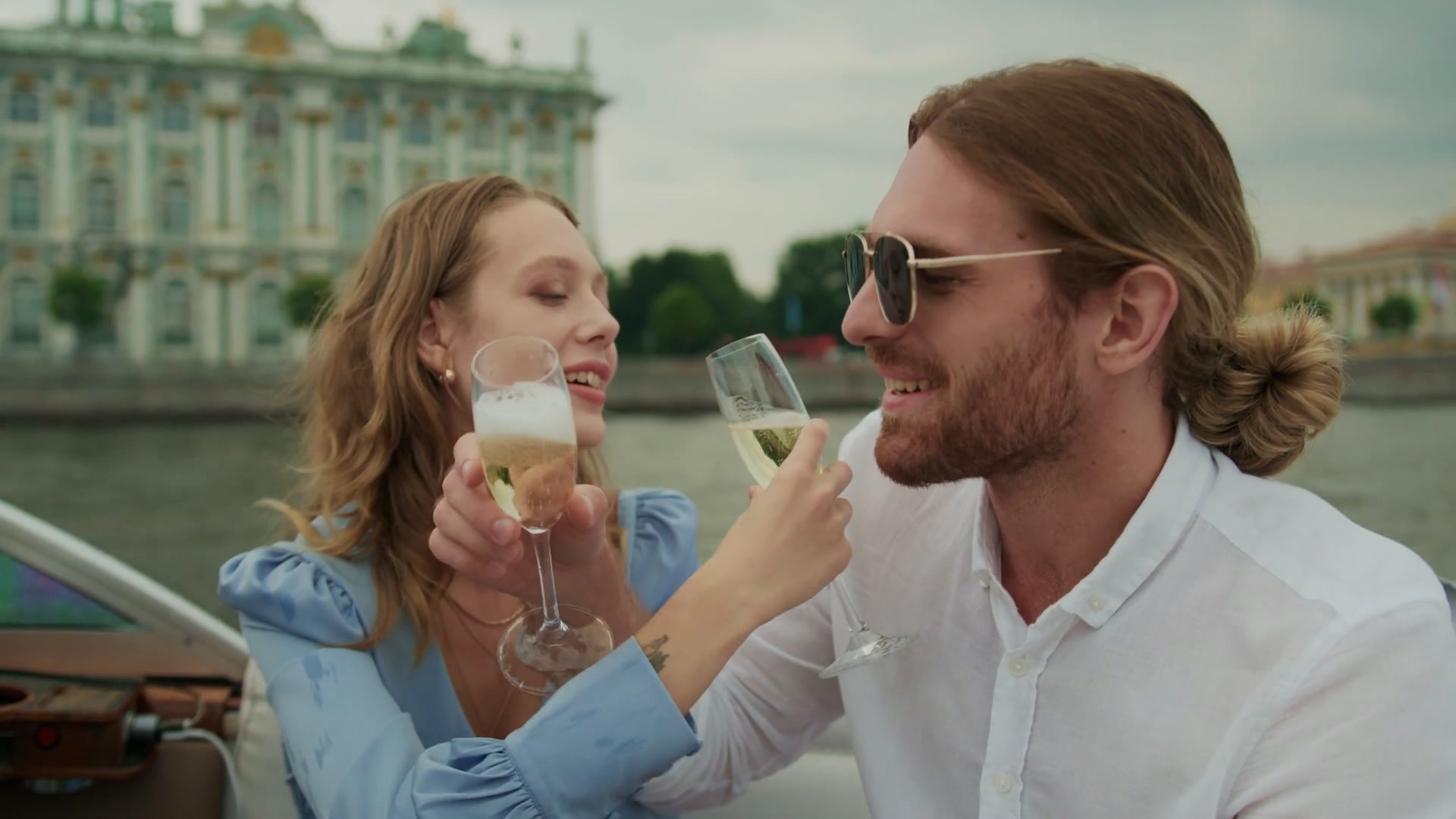 Two travellers raising glasses above the sea